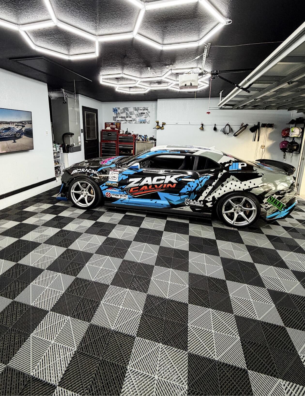 Car with 'Zack Calvin' branding in a garage with checkered floor and ceiling lights.