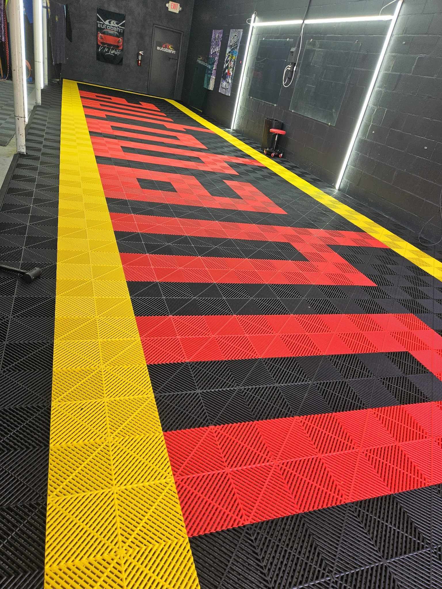 Rubber mat with red and yellow pattern on a black floor