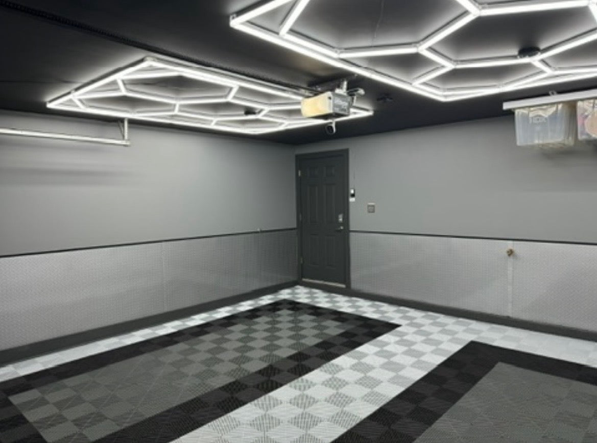 Modern garage interior with geometric ceiling lights and checkered floor.