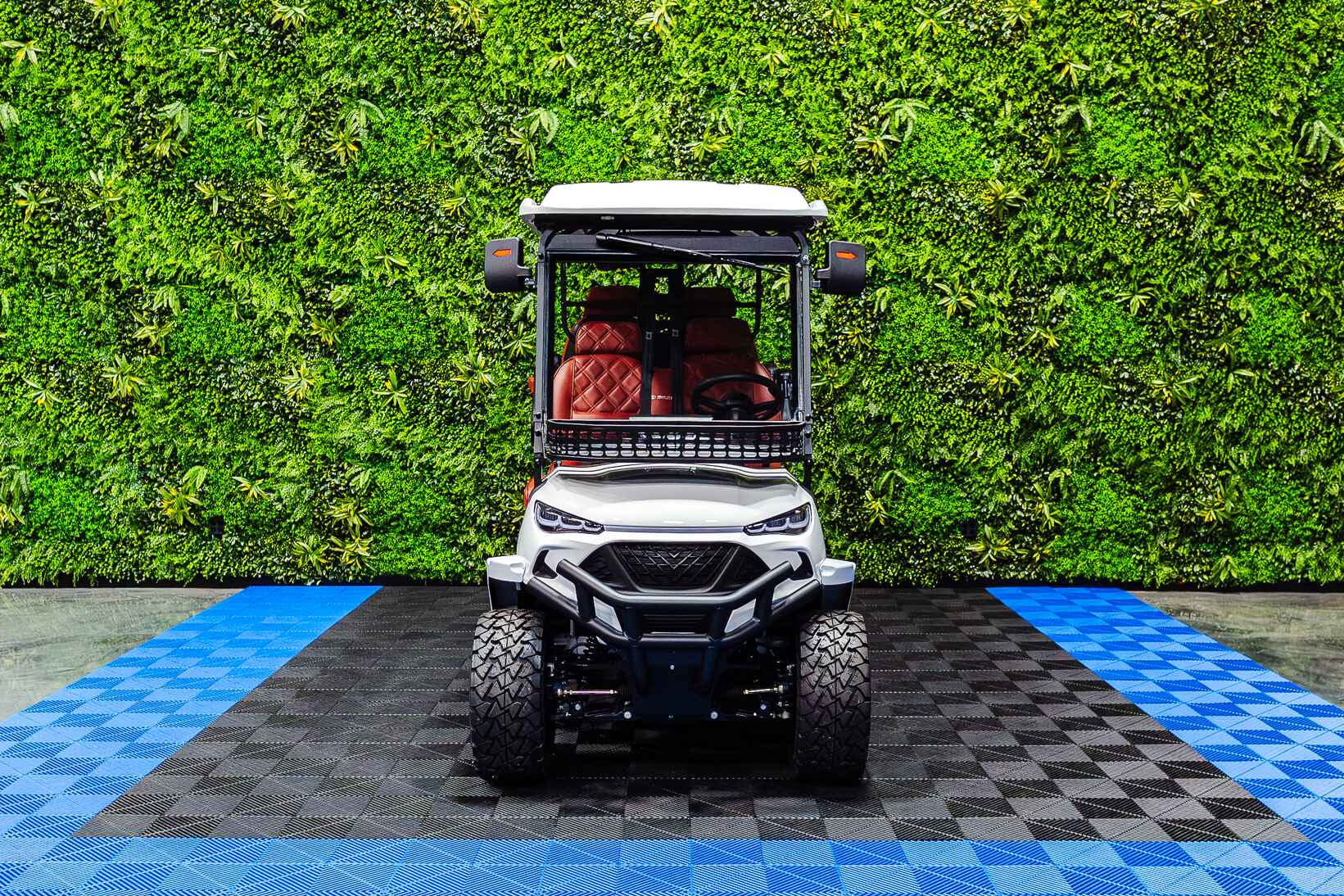 Golf cart on a checkered floor with a green wall background