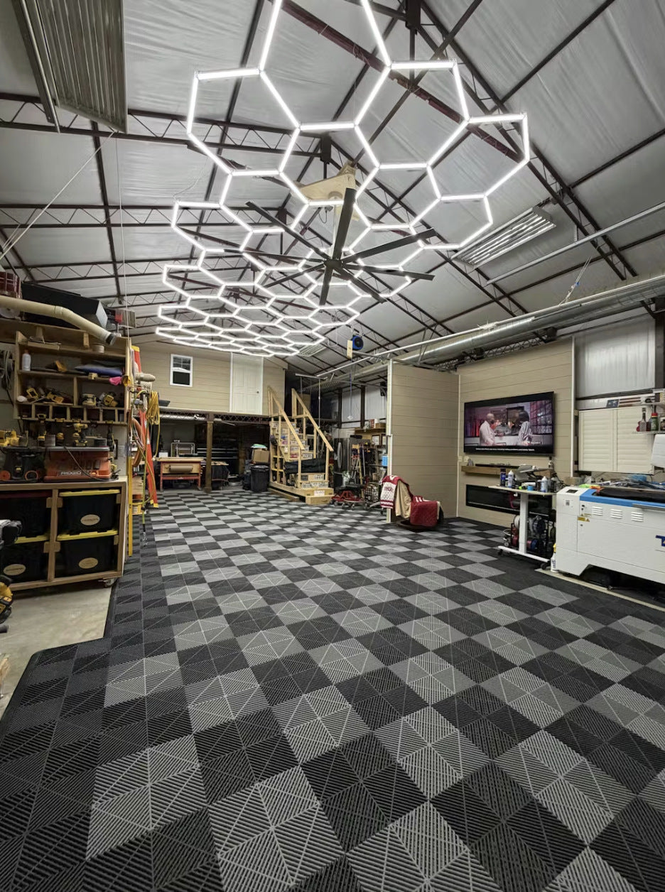 Garage interior with geometric ceiling lights, checkered floor, and various items on shelves.