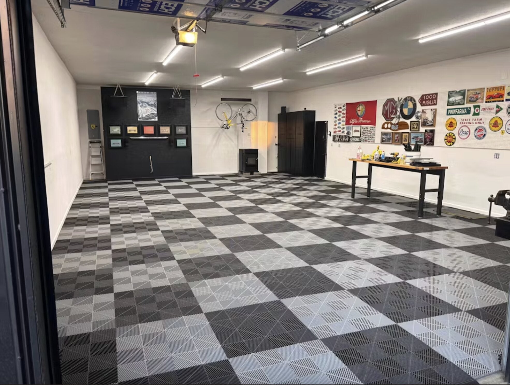 Garage interior with checkered floor, tools, and automotive decor.